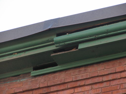 Cracked crown molding along the edge of a building's roof